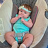 Lilith is registered to the contest to win money with this photo: baby, infant, child, car_seat, harness, headband, bow, turquoise_clothing, polka_dots, sitting, portrait, face, eyes, hand, finger, indoors, vehicle, travel, safe, adorable