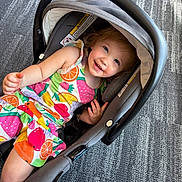 Wrenly joined the competition — help win amazing prizes! toddler, child, baby, smiling, happy, portrait, car_seat, infant_carrier, colorful_clothing, fruit_pattern, dress, red_hair, blue_eyes, lying_down, indoor, carpet, handle, safety_strap, playful, photography