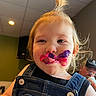 Wrenly joined the competition — help win amazing prizes! child, toddler, girl, face, portrait, smiling, playful, funny, lipstick, makeup, paint, moustache, denim, overalls, ponytail, blonde_hair, indoor, close_up, adult, background