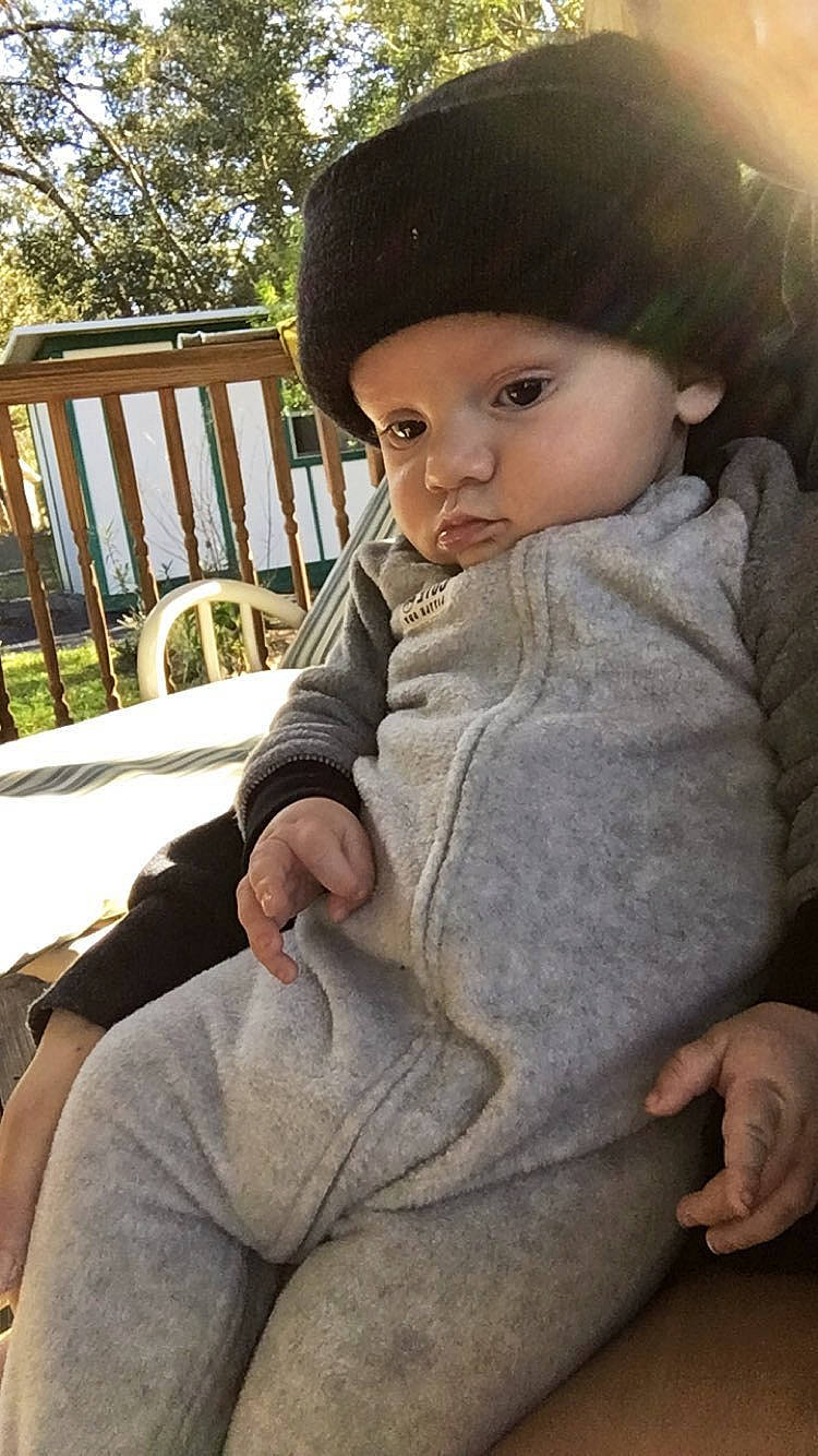 Ezequiel is registered to the contest to win money with this photo: cap, chair, chin, cool, doll, eye, grass, hairstyle, hat, headwear, human_body, lip, person, plant, skin, sleeve, sun_hat, toddler, toy, tree