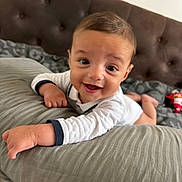 Mathis participe au concours pour gagner de l'argent avec cette photo : baby, smiling, infant, bed, pillow, indoor, happy, child, face, clothing, toddler, head, person, cute, young, sleeping_area, blanket, crawling, portrait, comfort