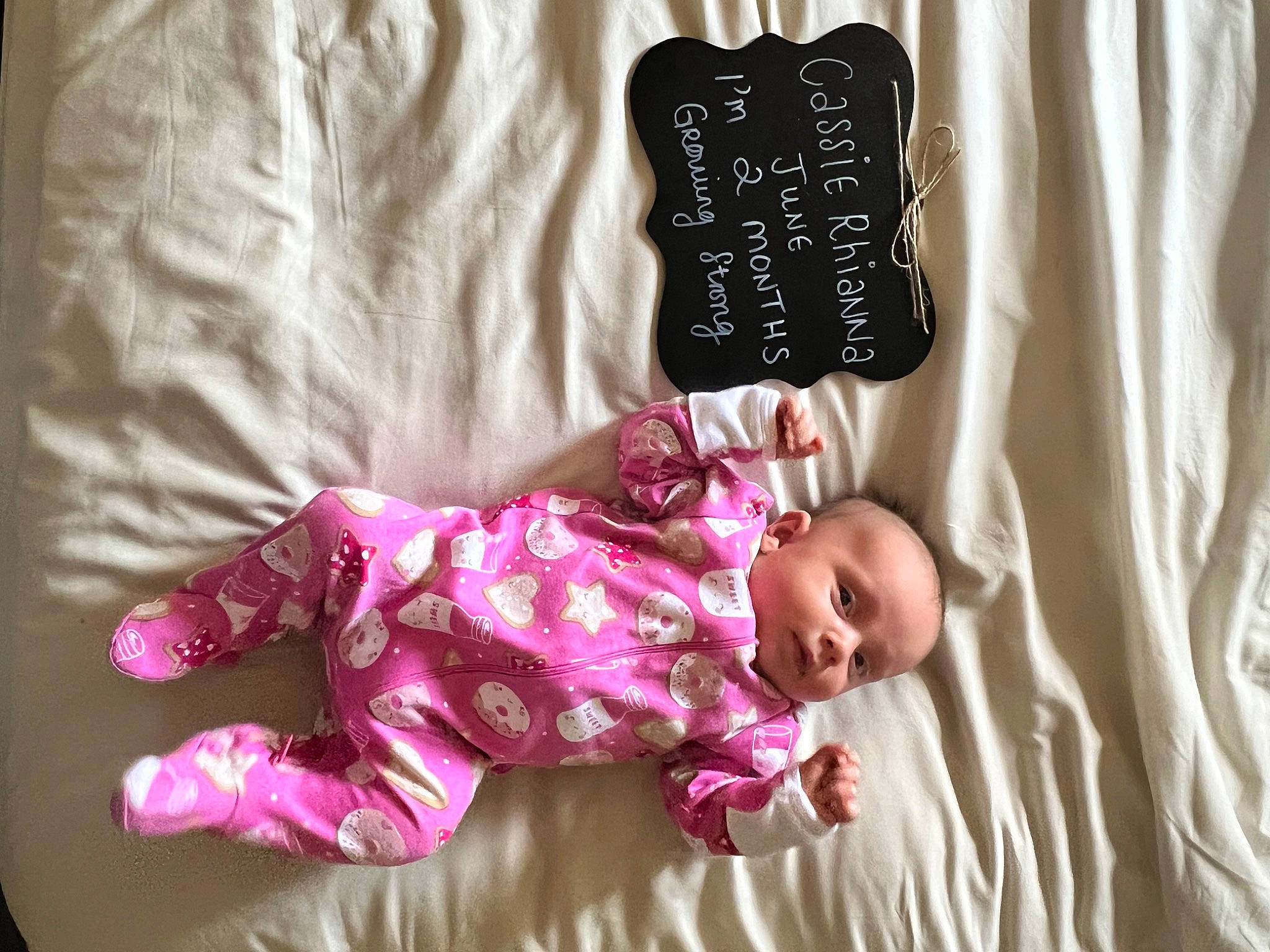 Cassie is registered to the contest to win money with this photo: baby, baby_toddler_clothing, beauty, bedding, child, comfort, font, foot, gesture, happy, linens, magenta, pattern, person, pink, room, sleeve, textile, toddler, wood
