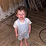 Valentin participe au concours pour gagner de l'argent avec cette photo : child, toddler, curly_hair, barefoot, wooden_floor, indoor, chairs, stacked_chairs, white_clothing, shorts, tshirt, distressed_expression, flash_photography, red_eye, wooden_wall, home_interior, floorboards, person, standing, young_child