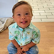 Logan participe au concours pour gagner de l'argent avec cette photo : barefoot, casual_clothing, child, cute, furniture, happy, indoor, jeans, person, playful, portrait, shirt, sitting, smiling, tile_floor, toddler, tongue_out, tropical_print, wooden_floor, young_child