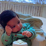 Yaman joined the competition — help win amazing prizes! baby, child, pajamas, blanket, chair, indoor, infant, cute, face, person, portrait, cushion, cozy, sitting, looking, hands, soft, home, window, daylight
