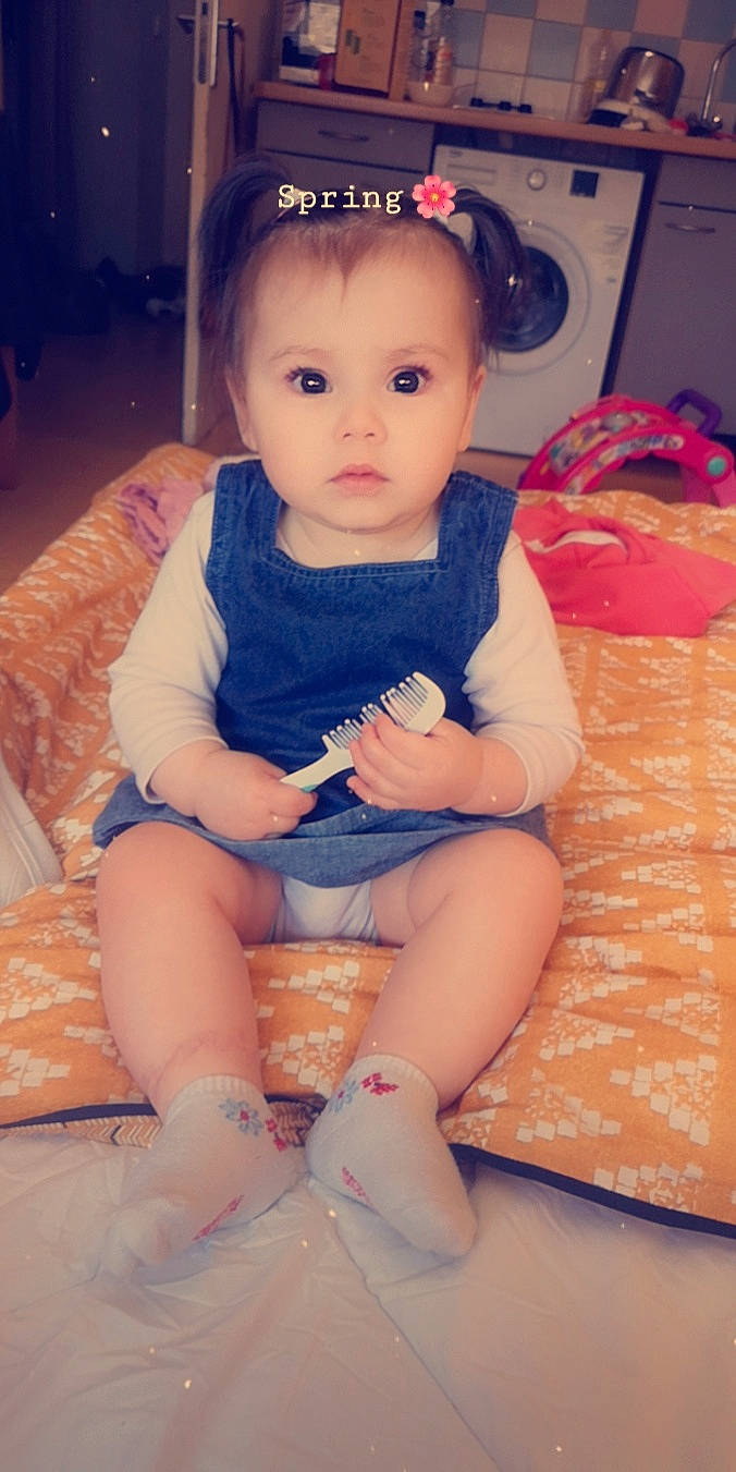 Nyna participe au concours pour gagner de l'argent avec cette photo : baby, baby_toddler_clothing, cheek, child, eye, hair_accessory, headband, iris, lip, person, pink, sitting, skin, toddler