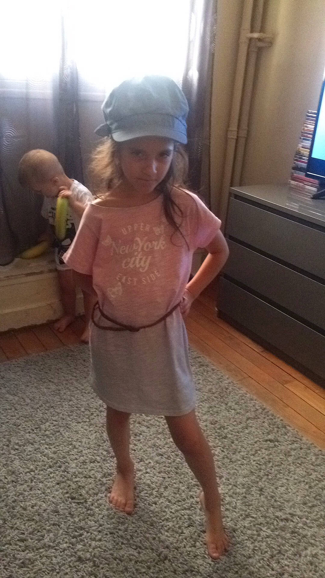 Nyna participe au concours pour gagner de l'argent avec cette photo : abdomen, arm, child, day, dress, finger, flooring, girl, headgear, human_body, human_hair_color, joint, leg, person, shoulder, skin, snapshot, standing, textile, toddler