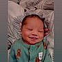 Wynston is registered to the contest to win money with this photo: newborn, baby, smiling, onesie, green_clothing, tiger_print, sleeping, peaceful, infant, cute, child, patterned_blanket, soft, portrait, closeup, face, happy, resting, cozy, human