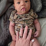Wynston joined the competition — help win amazing prizes! baby, infant, camo_onesie, hand, nails, cow_print_nails, ring, blanket, bed, skin, cute, wide_eyes, expression, person, fingers, soft_fabric, lying_down, indoors, comfort, child