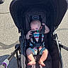 baby, babywear, casual, child, clothing, cute, footwear, infant, outdoor, pavement, person, playful, seatbelt, shade, stroller, summer, sunglasses, sunlight, toy, transport