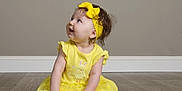 Gia joined the competition — help win amazing prizes! accessory, baby, child, curious, cute, fashion, floor, girl, happy, headband, indoor, infant, one_person, playful, portrait, shoe, sitting, smiling, wooden_floor, yellow_dress