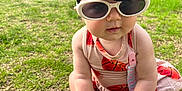 Gia joined the competition — help win amazing prizes! accessory, baby, background, child, cute, dress, fashion, fence, grass, hand, headband, outdoor, pacifier, person, playtime, shoe, summer, sunglasses, sunlight, yard
