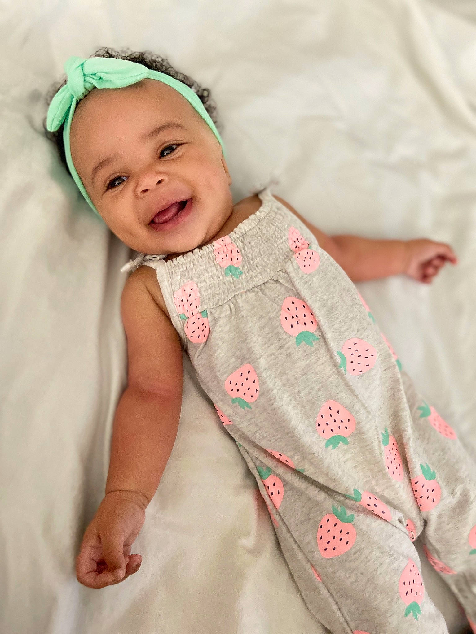 Capri is registered to the contest to win money with this photo: baby, baby_toddler_clothing, child, hair_accessory, linens, pattern, person, skin, smile, textile, toddler