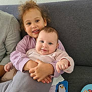 Amalïa participe au concours pour gagner de l'argent avec cette photo : baby, child, clothing, comfort, couch, cuddling, cute, face, family, happy, home, hug, indoor, love, person, playful, sitting, smile, toddler, toy