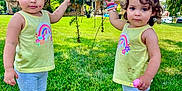 Anne E Alana joined the competition — help win amazing prizes! child, toddler, grass, tree, outdoor, yellow_tank_top, leggings, pink_shoes, bracelets, curly_hair, house, sky, clouds, greenery, daylight, playing, person, summer, nature, cute