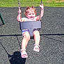 chains, child, curly_hair, fence, fun, grass, happy, outdoor, park, play, playground, recreation, sandals, seat, shadow, smiling, summer, sunny, swing, toddler