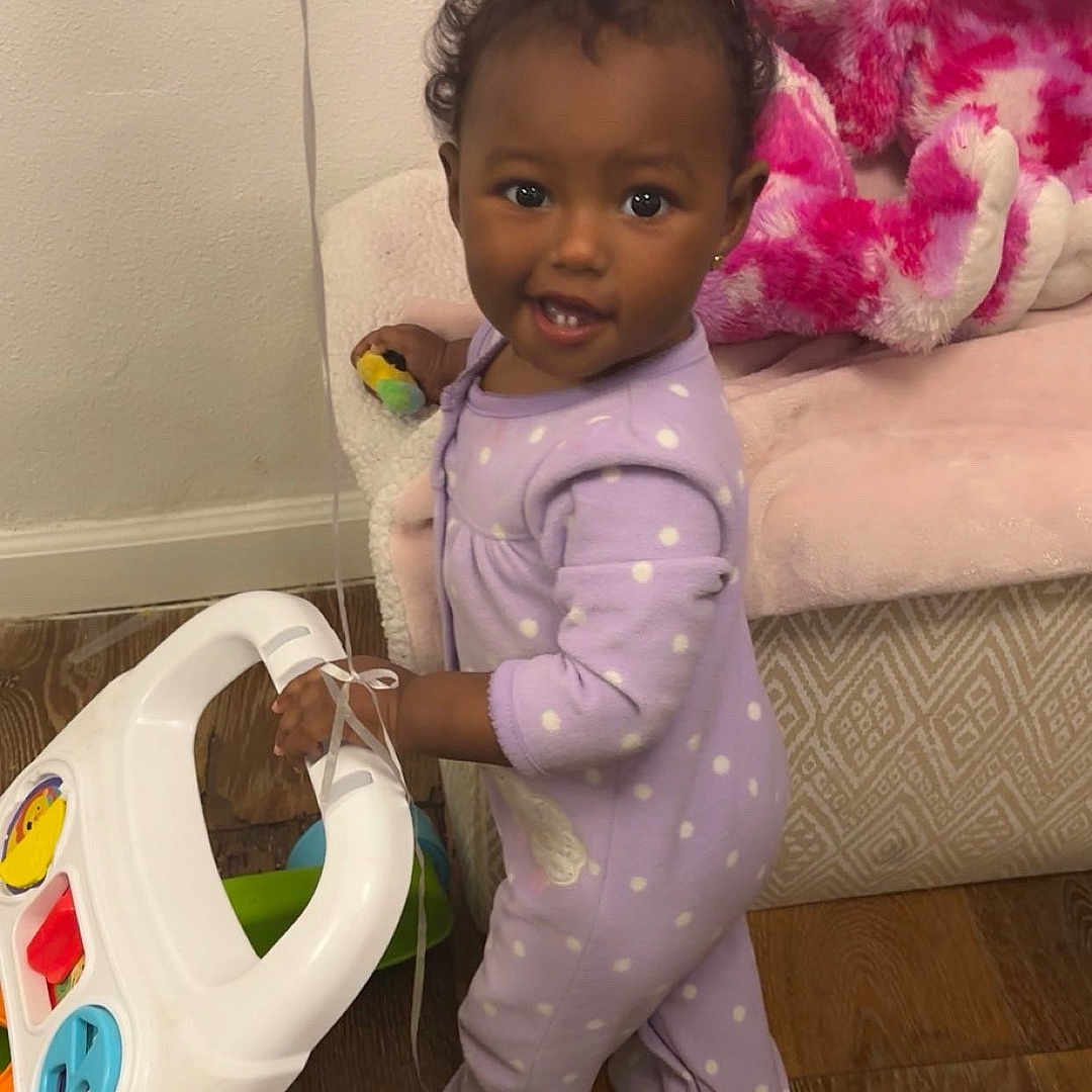 Airis is registered to the contest to win money with this photo: architecture, baby, building, clothing, couch, cushion, face, furniture, head, homedecor, indoors, livingroom, pajamas, person, photography, portrait, purple, room, tape, toy