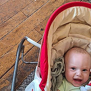Roman joined the competition — help win amazing prizes! baby, smiling, infant, baby_carrier, plush_toy, wooden_floor, carpet, clothing, happy, face, head, cushion, fabric, indoor, person, child, cute, comfort, seat, toy