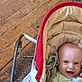 baby, smiling, infant, baby_carrier, plush_toy, wooden_floor, carpet, clothing, happy, face, head, cushion, fabric, indoor, person, child, cute, comfort, seat, toy