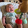 Emiliano is registered to the contest to win money with this photo: baby, infant, child, smiling, happy, sitting, bouncer, baby_chair, plush_toy, lion_toy, hanging_toys, rattle, colorful, indoors, window, blanket, patterned_fabric, onesie, portrait, feet