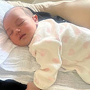 Aria participe au concours pour gagner de l'argent avec cette photo : baby, sleeping, onesie, pink_hearts, blanket, resting, soft, cozy, indoor, infant, peaceful, child, cute, face, hand, portrait, comfort, young, toddler, relaxation
