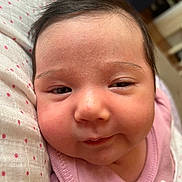 Mira is registered to the contest to win money with this photo: baby, blanket, child, close_up, cute, expression, face, hair, head, indoors, infant, newborn, pink_clothing, polka_dots, portrait, resting, skin, smiling, soft_texture, young_child