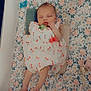 baby, sleeping, crib, blanket, floral_pattern, dress, pacifier, pillow, infant, peaceful, child, cute, soft, sleep, indoors, resting, toddler, fabric, comfort, bed