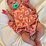 baby, infant, pacifier, headband, pink_dress, blanket, lying_down, cute, wide_eyes, hand_up, foot, soft_texture, indoor, newborn, child, person, clothing, fabric, resting, adorable
