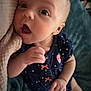 baby, infant, polka_dot, navy_blue, pink_bows, strawberry_patch, blanket, cushion, wide_eyes, surprised_expression, soft_texture, hand, foot, clothing, cute, child, portrait, indoors, snuggle, curiosity