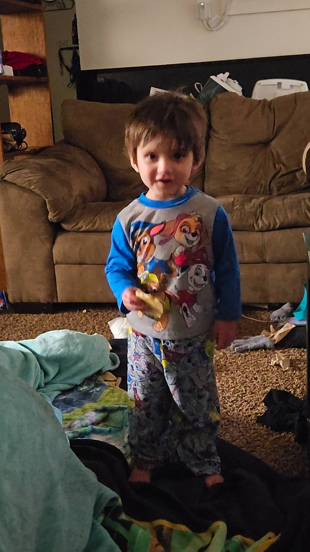 Kobe is registered to the contest to win money with this photo: child, comfort, couch, elbow, electronic_device, event, flooring, fun, happy, holiday, lap, living_room, pajamas, person, play, room, sitting, sleeve, smile, t_shirt