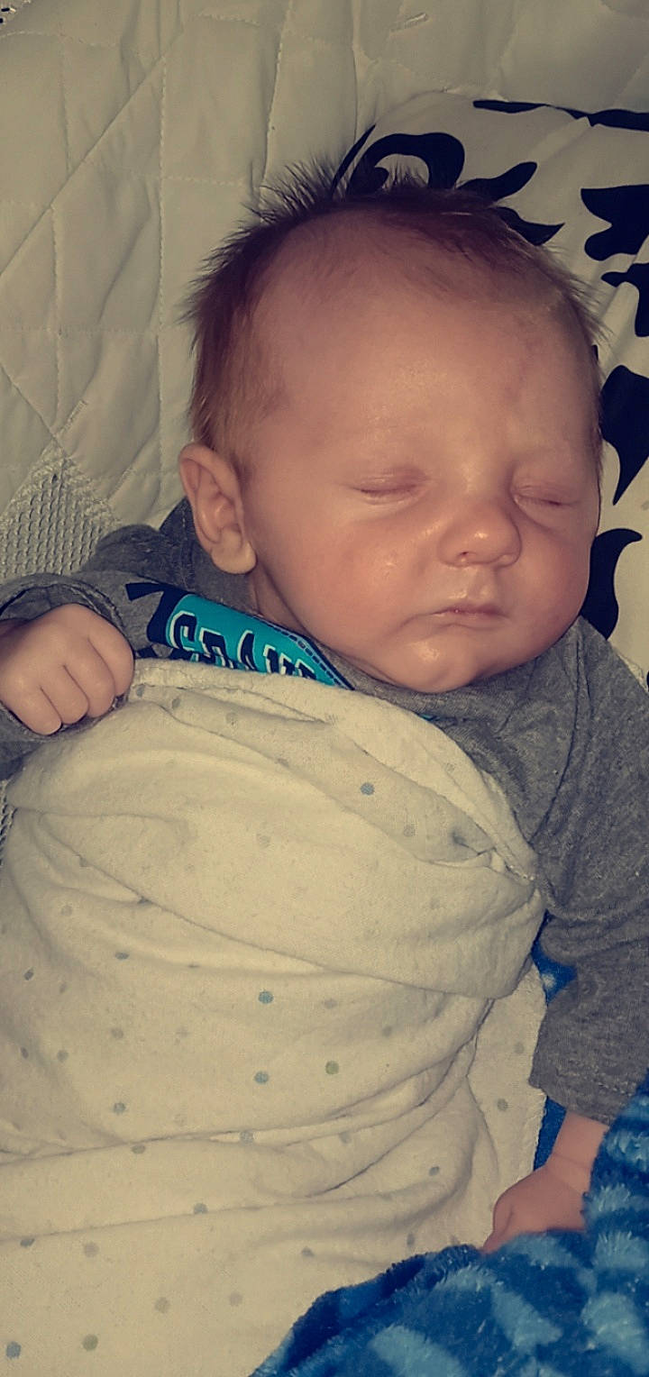 Kolton is registered to the contest to win money with this photo: baby, baby_toddler_clothing, cheek, chin, comfort, eyebrow, face, forehead, head, iris, lip, mammal, mouth, neck, nose, organ, person, skin, sleeve, standing