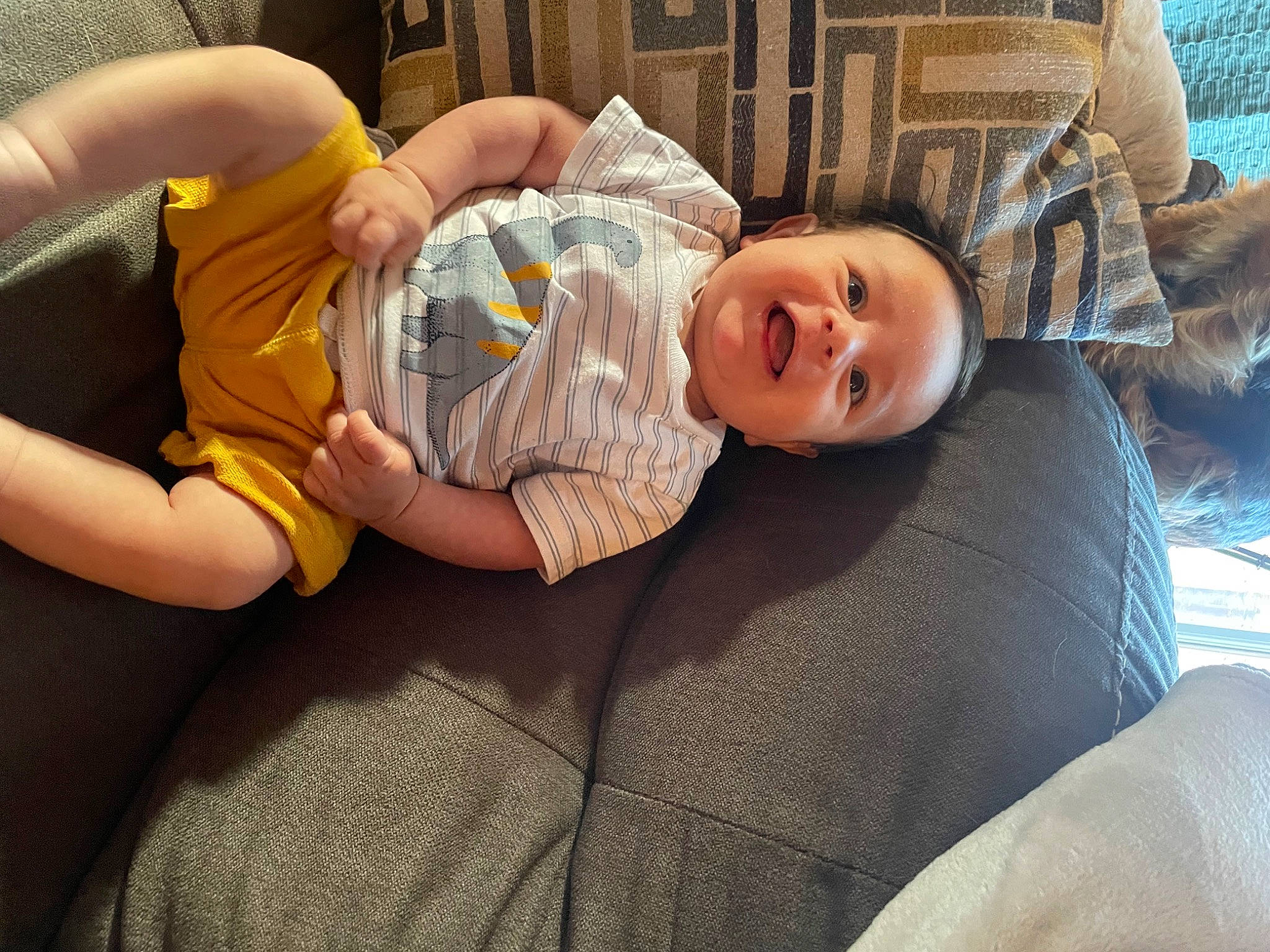 Peter joined the competition — help win amazing prizes! baby, baby_toddler_clothing, child, comfort, couch, finger, fun, happy, head, human_body, human_leg, knee, leg, linens, mouth, person, room, sitting, smile, thigh