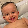 child, toddler, bathtub, smiling, wet_hair, face, happy, water, skin, teeth, head, ear, shoulder, bathroom, tile_wall, cute, joyful, portrait, indoors, baby