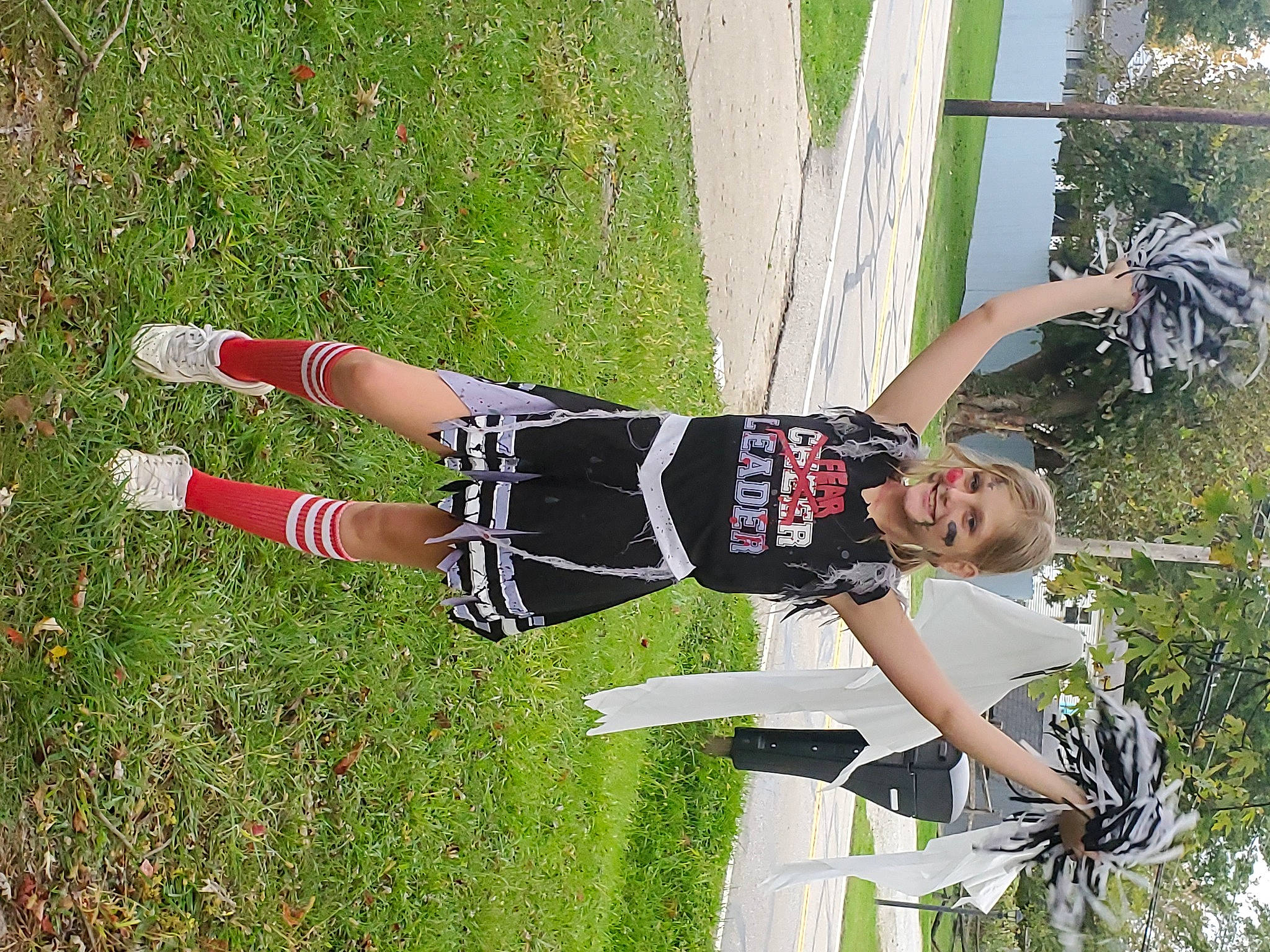 Miley is registered to the contest to win money with this photo: cheerleading_uniform, fun, grass, happy, human_leg, joy, knee, leisure, pattern, people_in_nature, person, plant, recreation, shorts, smile, sports, sports_uniform, sportswear, t_shirt, thigh