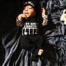 baby, infant, child, black_clothing, hat, pacifier, blanket, soft_texture, lying_down, cute, expression, hand, foot, colorful_sleeves, text_on_clothing, indoors, portrait, newborn, happy, cozy