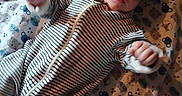 Atlas joined the competition — help win amazing prizes! baby, infant, striped_clothing, blanket, bear_pattern, face, hand, lying_down, cute, child, onesie, soft_fabric, cozy, portrait, indoors, young_child, small_hands, bedtime, comfort, sleepwear