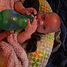 Atlas is registered to the contest to win money with this photo: baby, bottle, blanket, pillow, hand, face, infant, child, bed, clothing, soft_texture, patterned, colorful, person, indoors, resting, cute, young, holding, curious