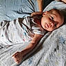 Atlas is registered to the contest to win money with this photo: baby, infant, blanket, bed, arm, person, sleepwear, soft_texture, indoor, resting, young_child, cute, sleeping_area, peaceful, skin, hand, head, face, lying_down, calm