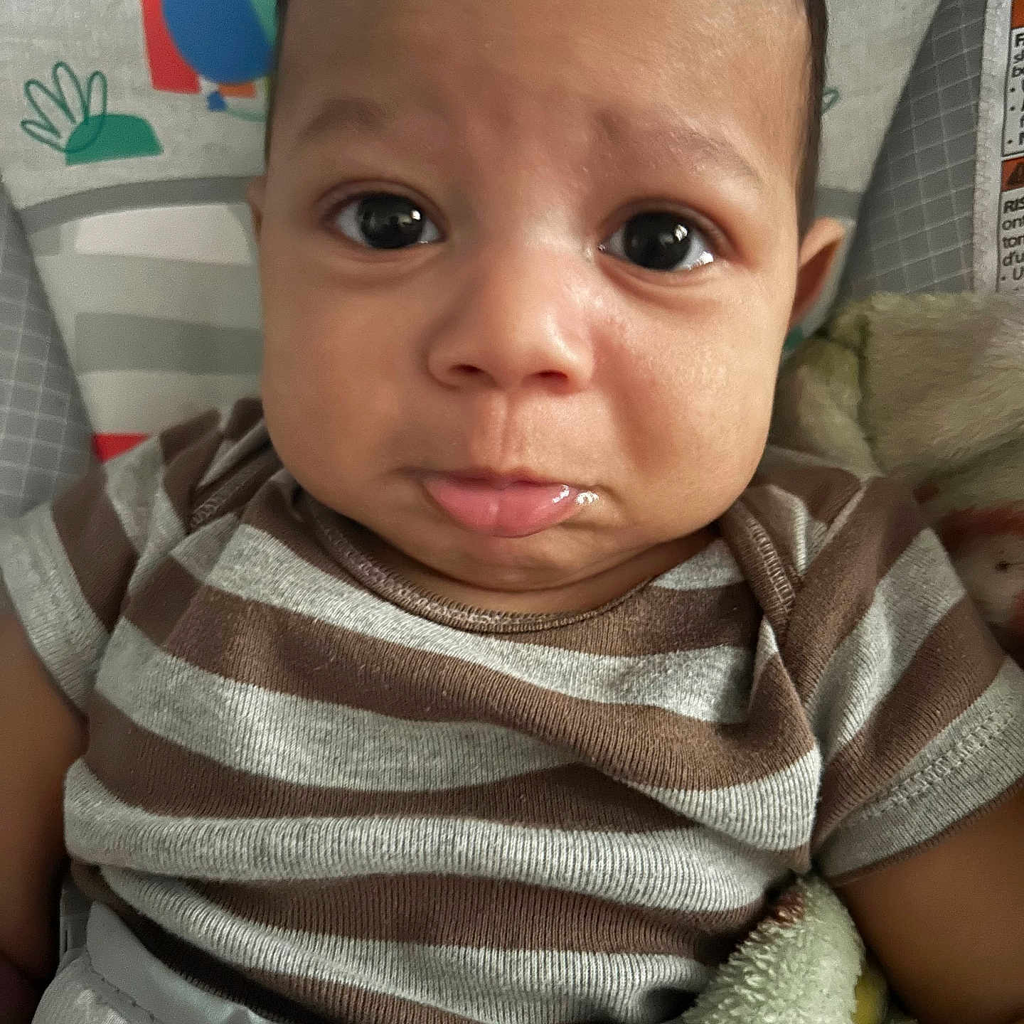 Sylas is registered to the contest to win money with this photo: baby, blanket, child, closeup, clothing, colorful, comfort, cute, expression, eyes, face, indoors, infant, person, portrait, pout, seat, soft_texture, striped_shirt, young_child