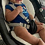 baby, smiling, baby_rocker, blue_onesie, safety_straps, indoor, furniture, cushion, person, child, happy, seated, foot, hand, head, face, clothing, fabric, infant, home