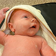 Bodhi is registered to the contest to win money with this photo: baby, infant, towel, skin, hand, face, eyes, mouth, newborn, lying_down, expression, curious, blanket, indoors, soft_texture, closeup, human, child, cute, portrait