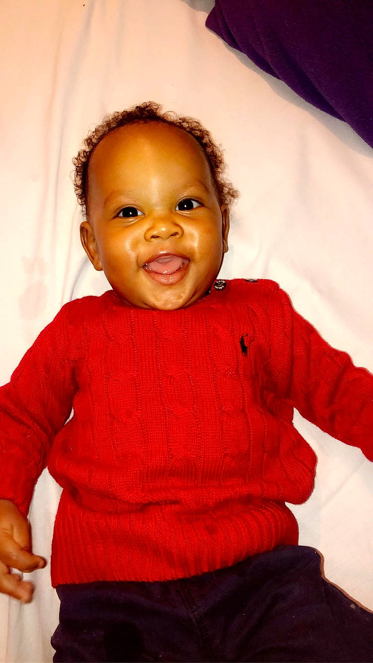 Zayden a rejoint le concours — aidez-le/la à gagner de superbes lots ! baby, cheek, child, face, head, lip, outerwear, person, red, sitting, skin, smile, standing, toddler