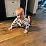 Renley is registered to the contest to win money with this photo: baby, crawling, floor, wooden_floor, floral_clothing, indoors, child, person, curious, home, natural_light, head, hands, legs, infant, room, background, soft_light, expression, young
