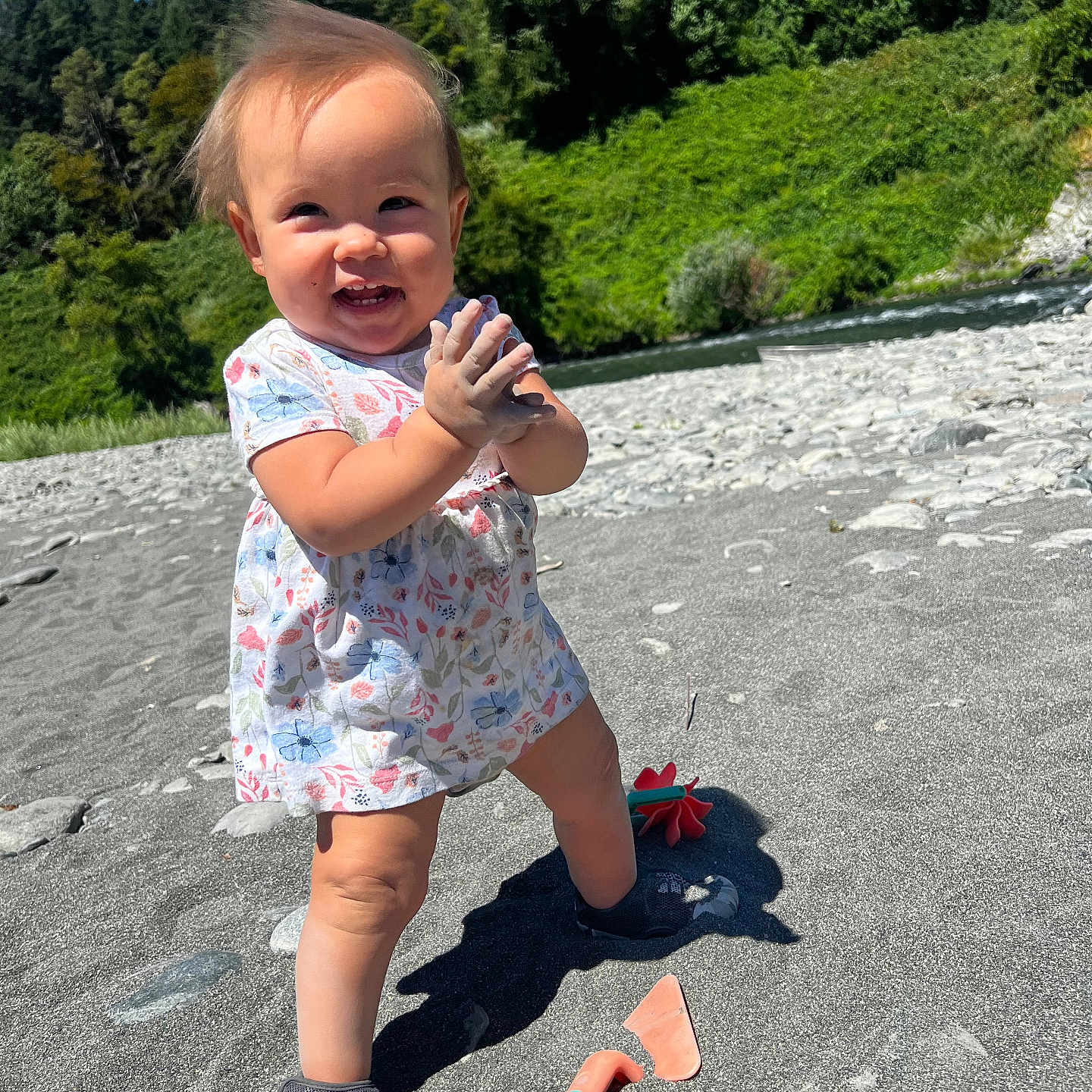 Kalina is registered to the contest to win money with this photo: baby, beach, child, clapping, daytime, dress, happy, nature, outdoor, person, play, river, rocks, sand, shoes, smiling, sunny, toddler, toys, trees