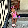 Zariyah is registered to the contest to win money with this photo: brick_wall, casual_clothing, child, colorful_shorts, concrete, concrete_floor, curious_expression, daylight, girl, outdoor, pink_headband, pink_tank_top, portrait, railing, sandals, sippy_cup, sitting, steps, toddler, young_child