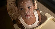 Zariyah joined the competition — help win amazing prizes! baby_food, carpet, child, curiosity, curly_hair, cute, expression, face_paint, feeding, food, furniture, high_chair, indoor, messy, plate, portrait, spoon, table, toddler, white_tank_top
