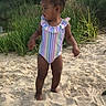 barefoot, beach, child, curious, daytime, grass, greenery, nature, outdoor, person, playful, sand, standing, summer, sunlight, swimsuit, toddler, trees, vacation, young_child