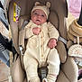 baby, infant, car_seat, knitwear, onesie, hat, slippers, bear_theme, face, person, indoor, soft_toys, baby_accessory, comfort, cute, child, newborn, seated, warm_clothing, neutral_colors