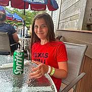 Isabella joined the competition — help win amazing prizes! child, girl, smiling, red_shirt, sprite_can, glass_table, outdoor, umbrella, samuel_adams, restaurant, dining, chair, wristband, wooden_wall, people, summer, casual, happy, daylight, portrait