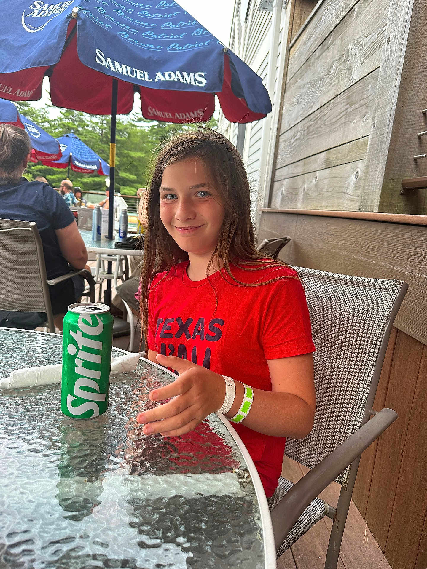 Isabella joined the competition — help win amazing prizes! child, girl, smiling, red_shirt, sprite_can, glass_table, outdoor, umbrella, samuel_adams, restaurant, dining, chair, wristband, wooden_wall, people, summer, casual, happy, daylight, portrait